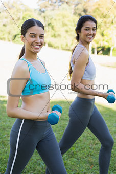 Sporty women lifting hand weights