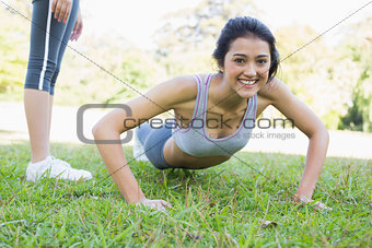 Beautiful woman doing push ups in park
