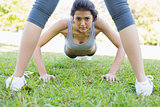 Confident woman doing push ups in park