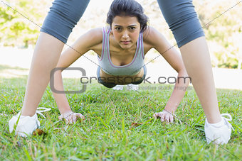 Confident woman doing push ups in park