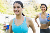 Fit women with water bottle jogging