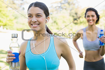 Fit women with water bottle jogging