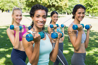 Confident sporty women lifting hands weights