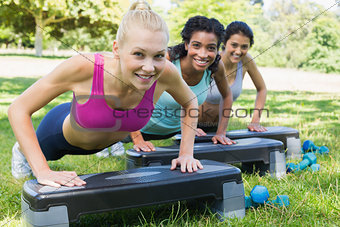 Sporty women doing step aerobics