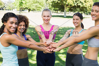 Female friends stacking hands in park