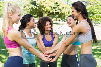 Female friends with hands stacked together