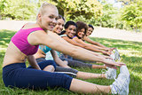 Women performing stretching exercise at park