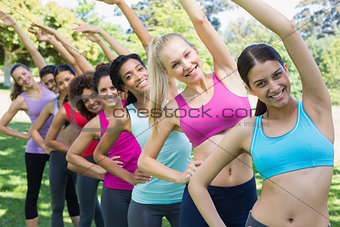 Multiethnic friends doing stretching exercise at park