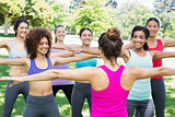 Women exercising with instructor at park