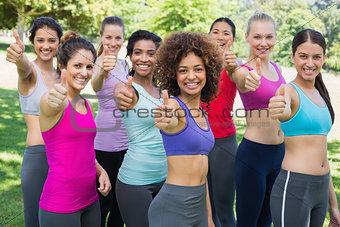 Sporty women gesturing thumbs up in park