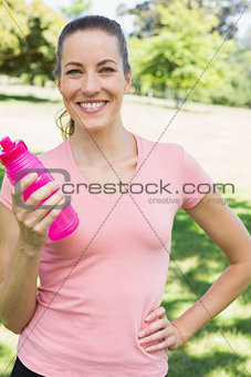 Sporty woman holding water bottle in park