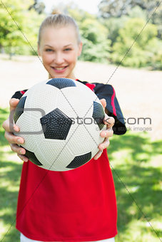 Female soccer player showing ball at park