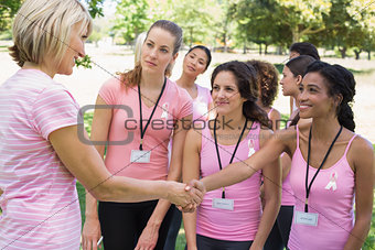 Participants shaking hands during breast cancer awareness