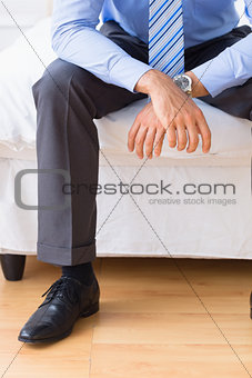 Businessman sitting on his bed