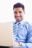 Happy businessman on couch using his laptop