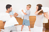 Happy young family having a pillow fight