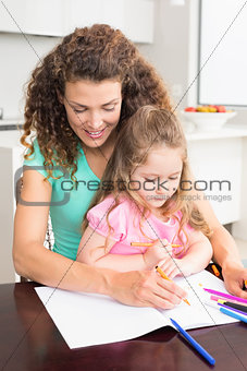 Mother and daughter colouring together at the table