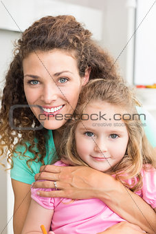 Smiling mother and daughter cuddling