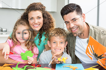 Happy young family doing arts and crafts at the table