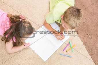 Siblings colouring on the rug
