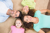 Happy family lying on the rug in a circle