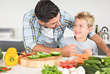 Smiling father preparing vegetables with his son