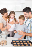Cheerful family having cookies and milk