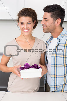 Smiling woman holding a gift from her partner