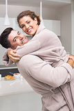 Smiling man lifting and hugging his partner in the morning