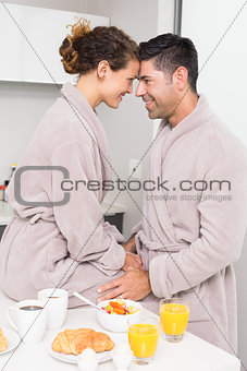 Romantic couple in bathrobes having breakfast together