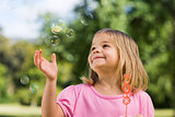 Girl looking at soap bubbles at park