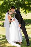 Romantic newlywed couple kissing in park