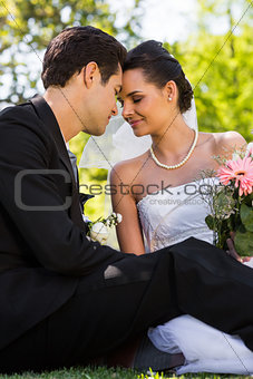 Romantic newlywed couple sitting in park
