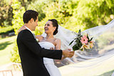 Cheerful newlywed couple dancing in park