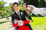Newlywed couple enjoying scooter ride