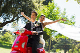 Newlywed couple enjoying scooter ride