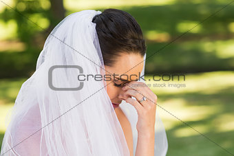 Close-up of beautiful worried bride at park