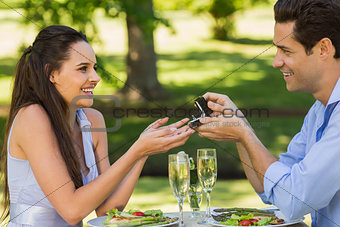 Man propose woman while they have romantic date at an outdoor café