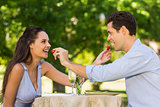Couple feeding strawberries to each other at outdoor café