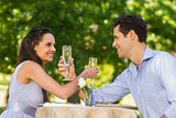 Couple with champagne flutes sitting at outdoor café
