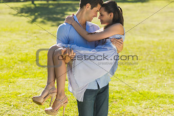 Man carrying a woman in park