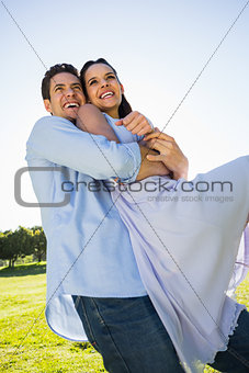 Happy man carrying woman at the park