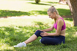Healthy and beautiful woman in sportswear sitting in park