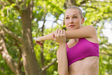Healthy and beautiful woman stretching hand in park