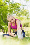 Healthy and beautiful woman stretching hand to leg in park