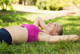 Relaxed woman lying on grass in park