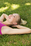 Relaxed beautiful woman lying on grass in park