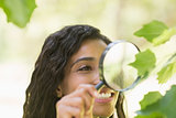 Woman examining leaves with magnifying glass