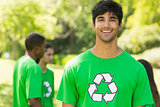 Smiling man wearing green recycling t-shirt in park