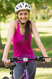 Fit young woman with helmet riding bicycle